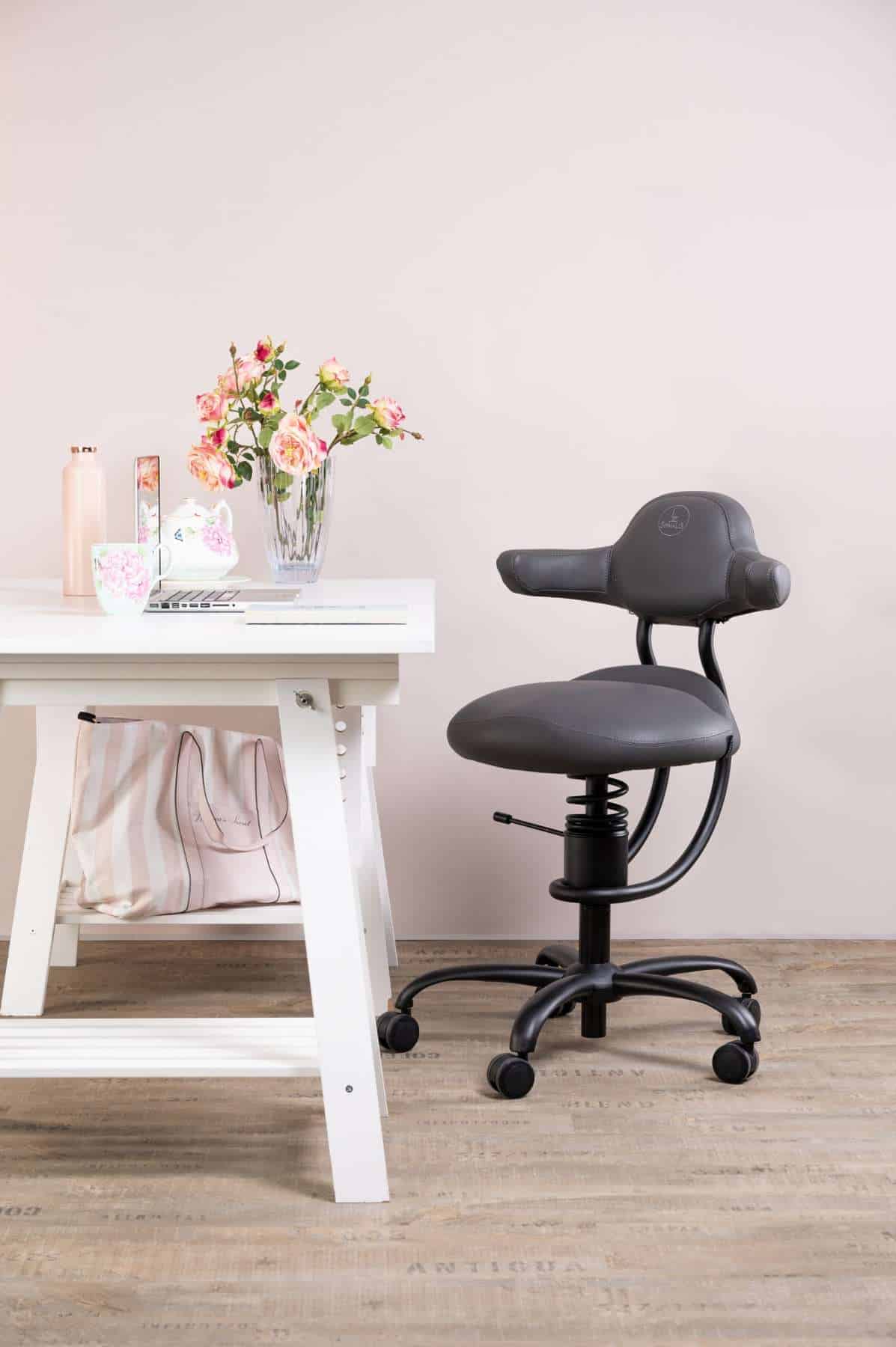 Pisarniški stol Explorer v sivi barvi poleg pisalne mize